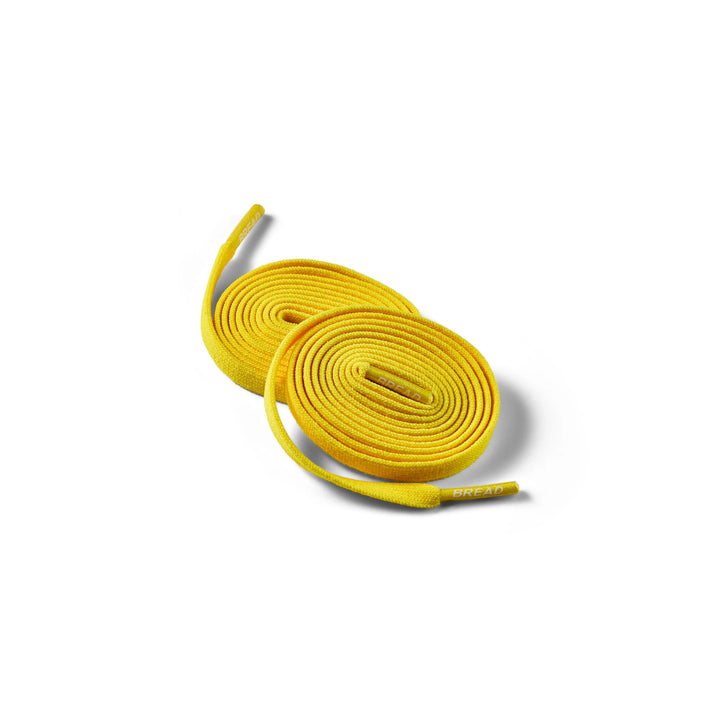 Elastic shoelace in vibrant yellow from Bread's Corona Yellow collection, showing the flexible, durable design on a plain background.