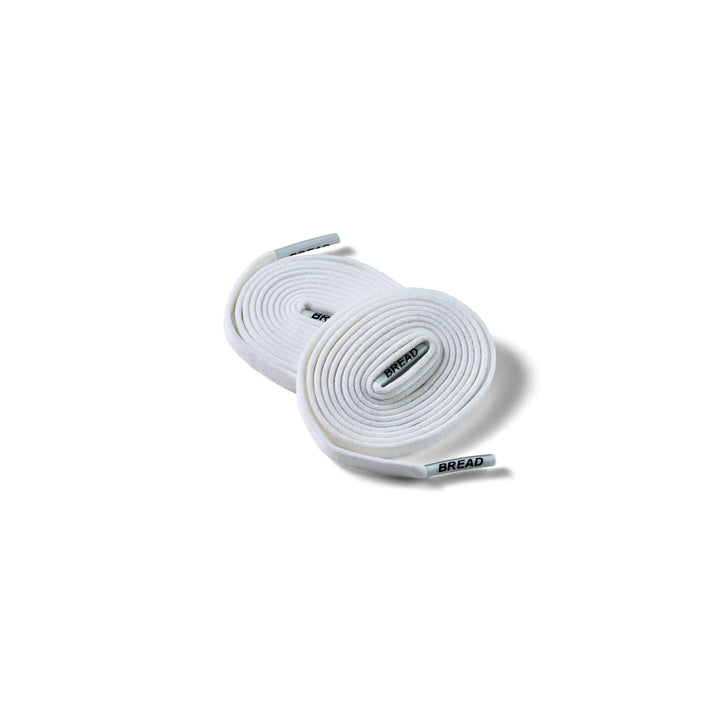 Elastic shoelace in cloud white by Bread, showing the soft, stretchy cord with aglets for easy lacing and secure fit.