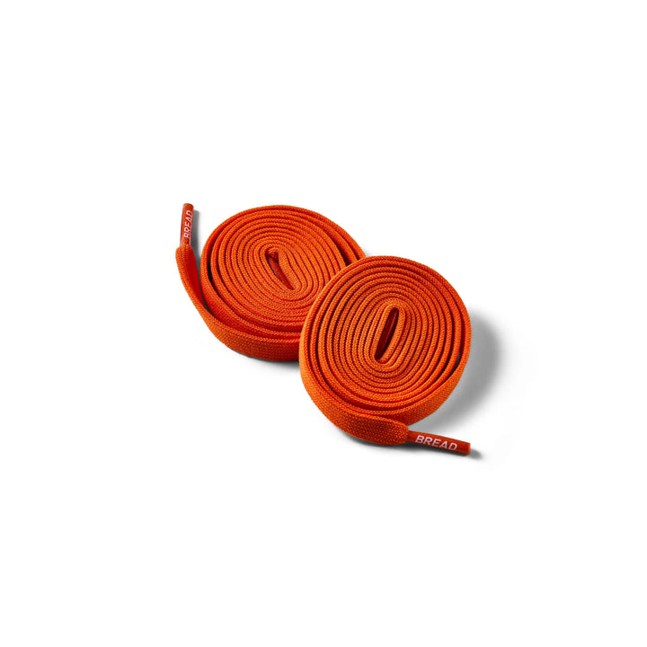 Elastic coral orange shoelace by Bread, showing its vibrant color and flexible design for easy lacing and secure fit.
