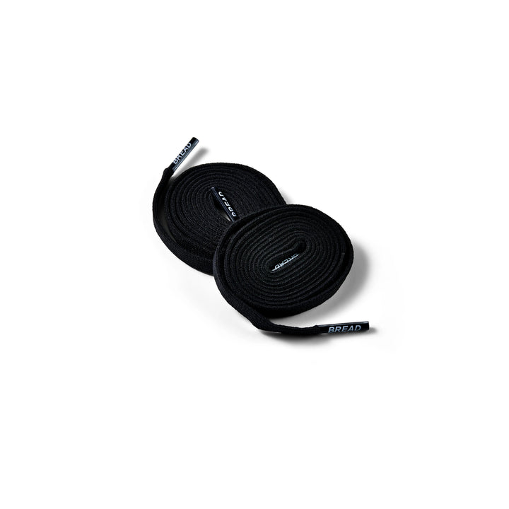 Black elastic shoelace by Bread, lightweight and flexible, designed for easy fitting and secure fastening on athletic shoes.