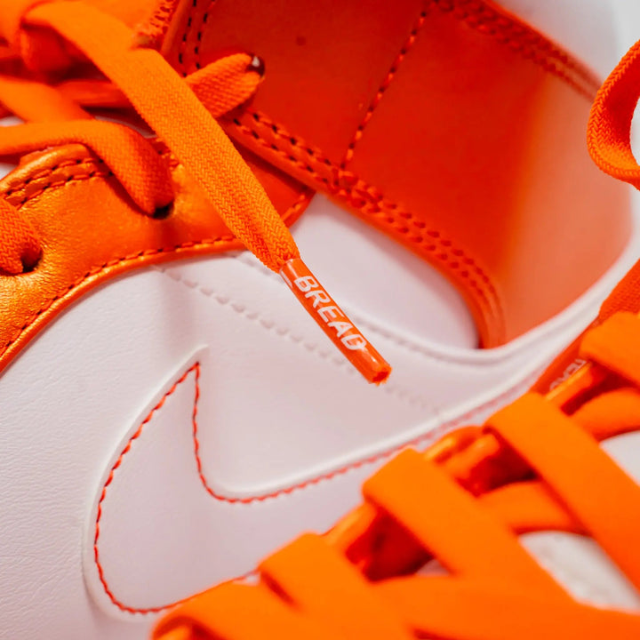 Coral orange elastic shoelace by Bread, close-up showing flexible, stretchable material and vibrant coral orange color.