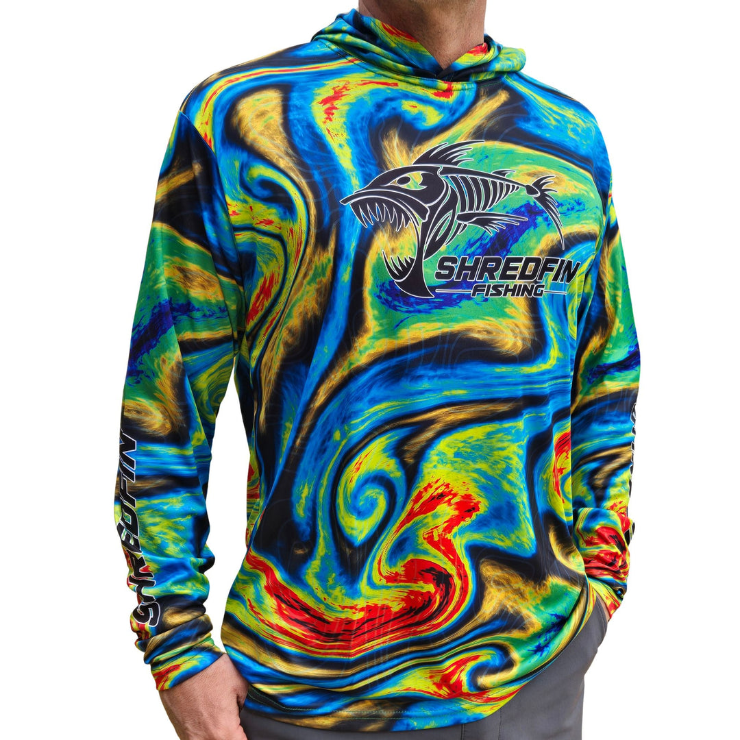 Cream ShredFin StormSurge hooded performance shirt with Sonar Swirl design, displayed on a minimalist living room setting.