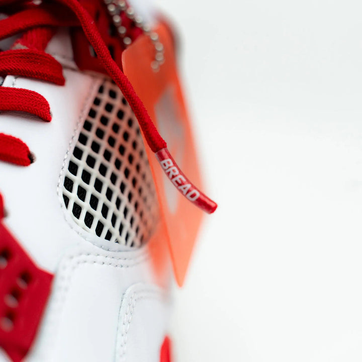Bright red elastic shoelace by Bread, showing the flexible, stretchy design suitable for sneakers or casual shoes.