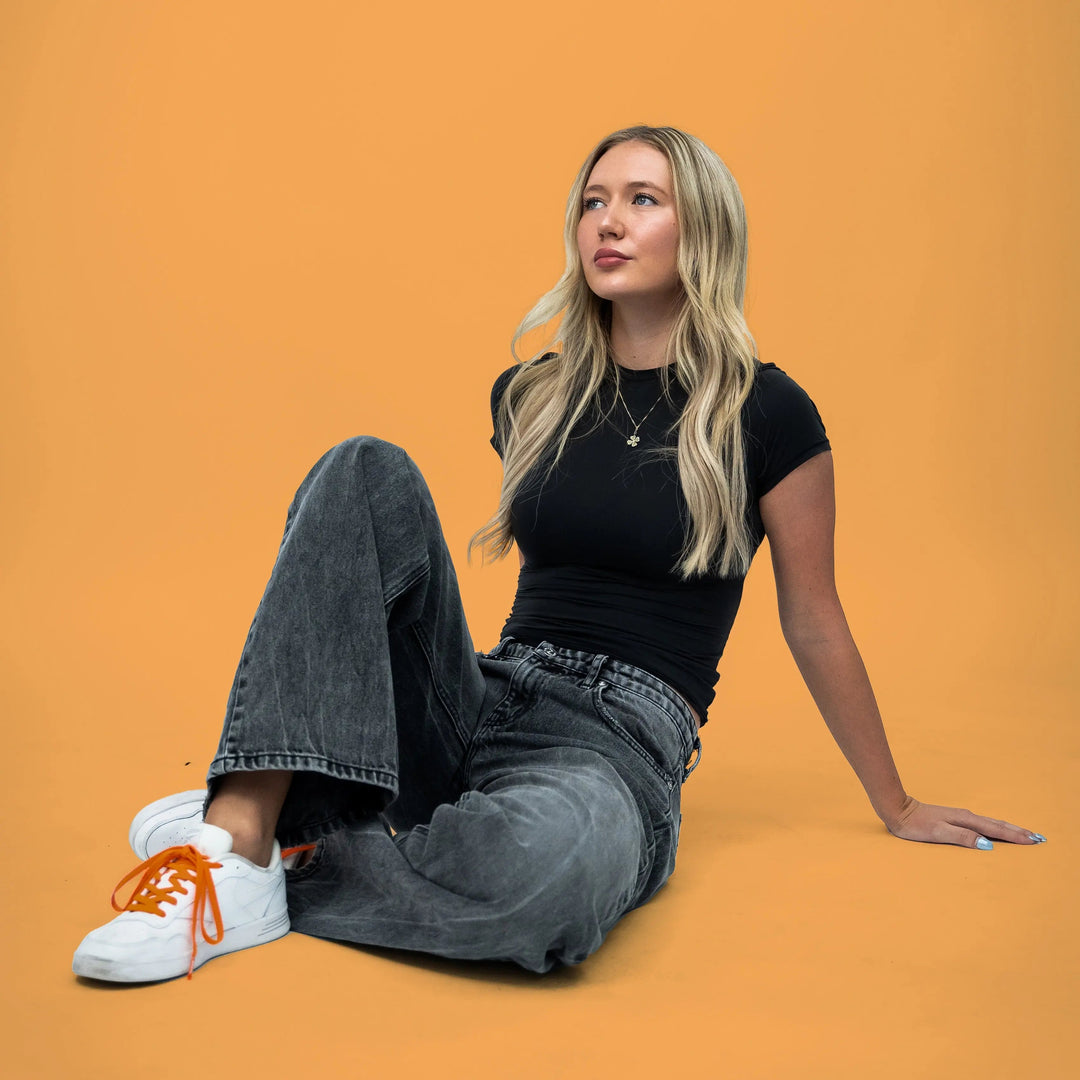 Elastic shoelace in coral orange by Bread, showing its stretchy, vibrant design suitable for casual and athletic footwear.
