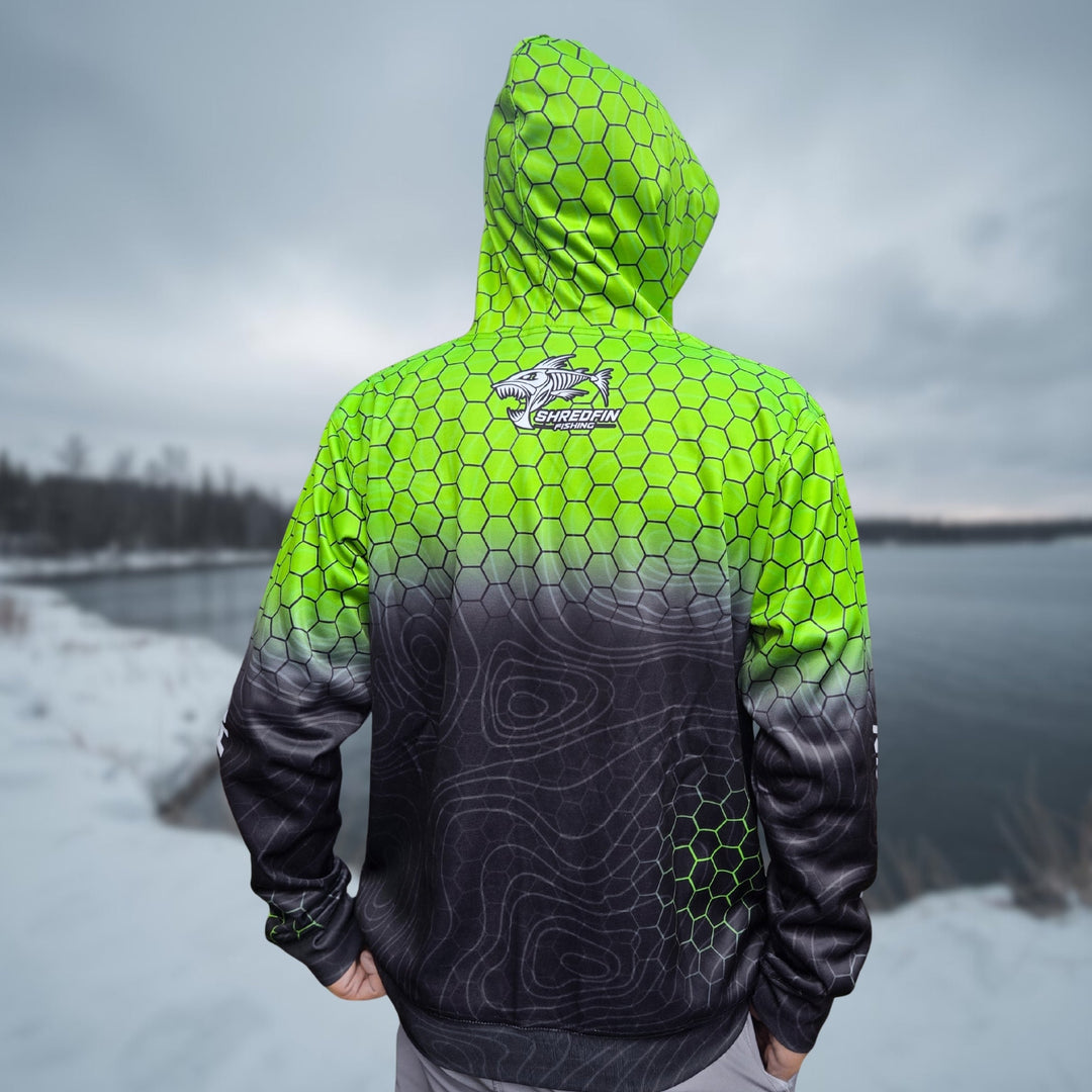 ShredFin HexCast Elite Performance Hoodie in chartreuse and black fade, shown outdoors with a person and a dog near a lake.