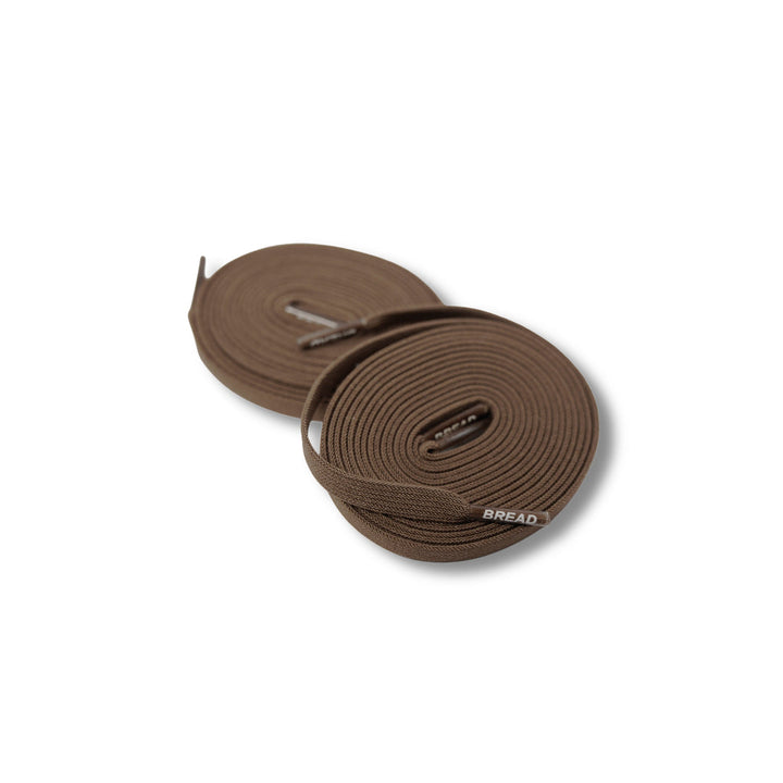 Rich brown elastic shoelace from Bread, showing close-up view of flexible, durable laces with metal aglets for sneakers or casual shoes.