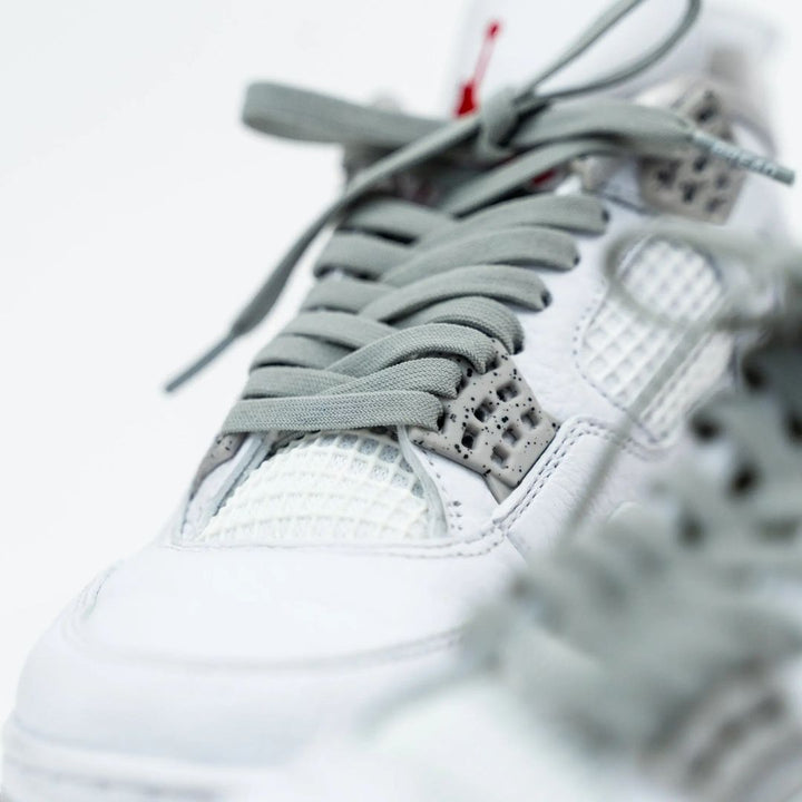 Gray elastic shoelace by Bread, Vulture Gray, shown threaded through sneaker eyelets for a flexible, comfortable fit.