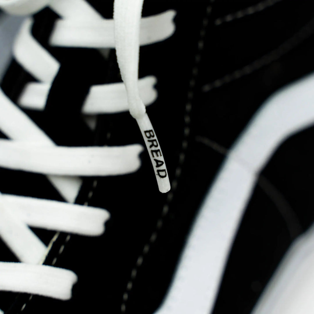 Elastic shoelace in cloud white by Bread, shown threaded through Vans sneakers, offering a snug and stylish fit.