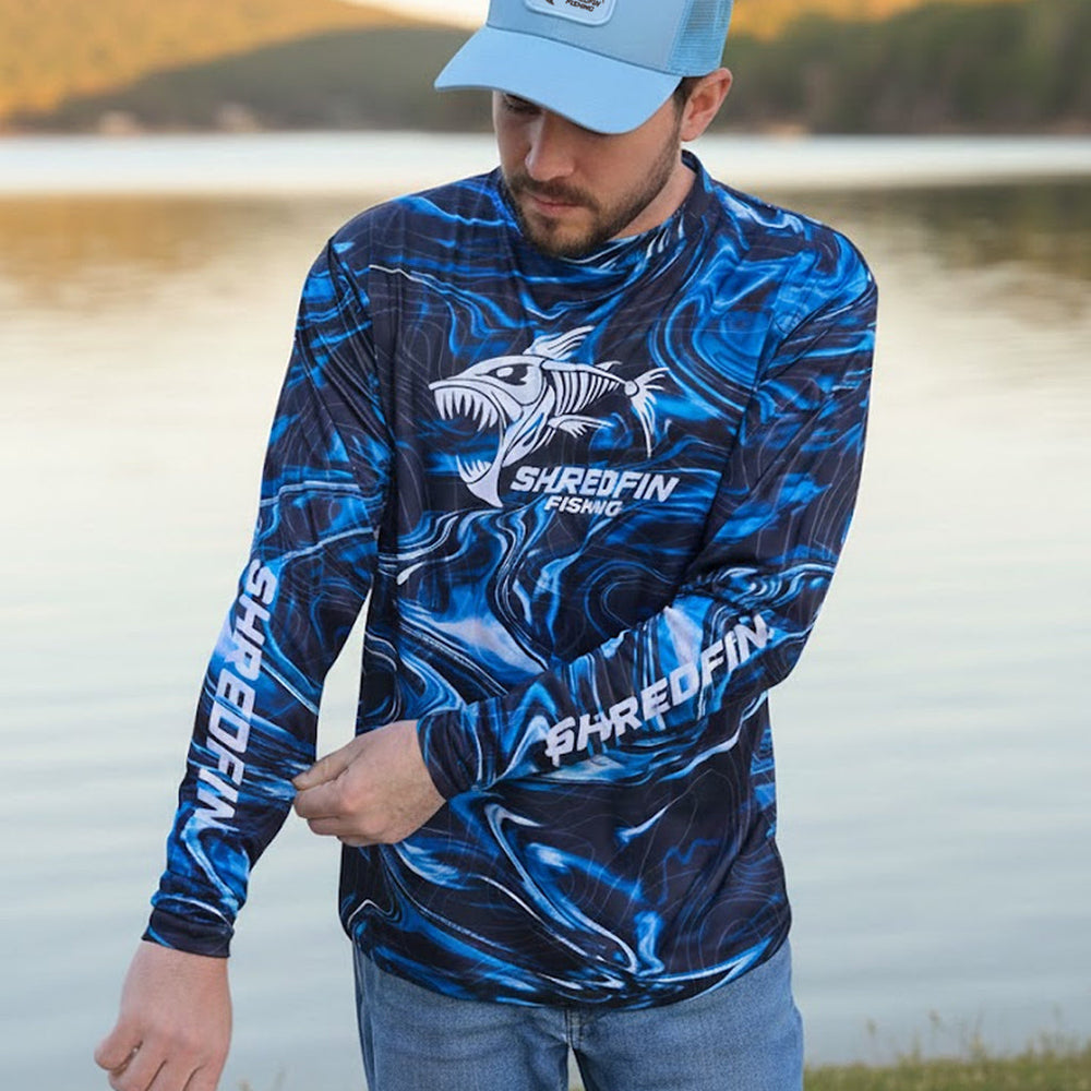 ShredFin StormSurge Performance Shirt in Blue Abyss, lightweight athletic top with moisture-wicking fabric, styled in a casual outdoor setting.