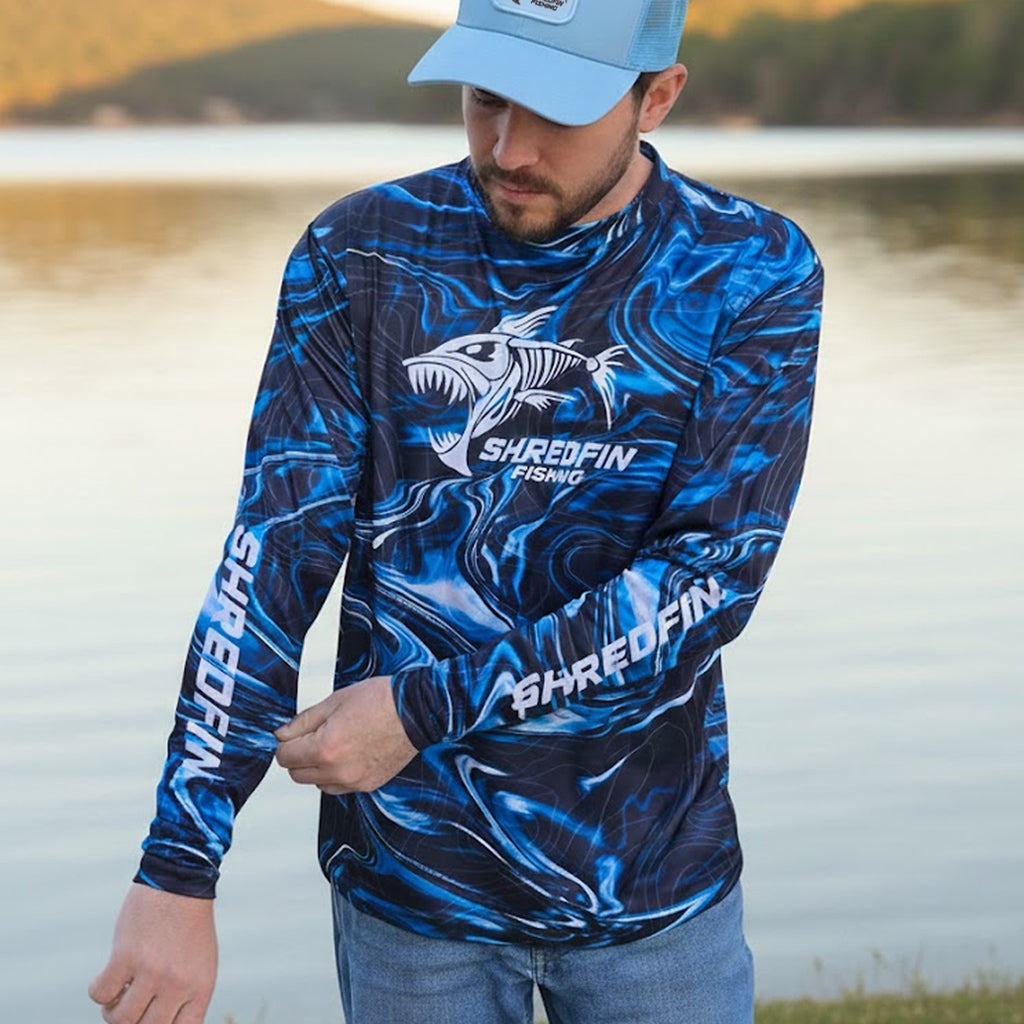 ShredFin StormSurge Performance Shirt in Blue Abyss, lightweight athletic top with moisture-wicking fabric, styled in a casual outdoor setting.