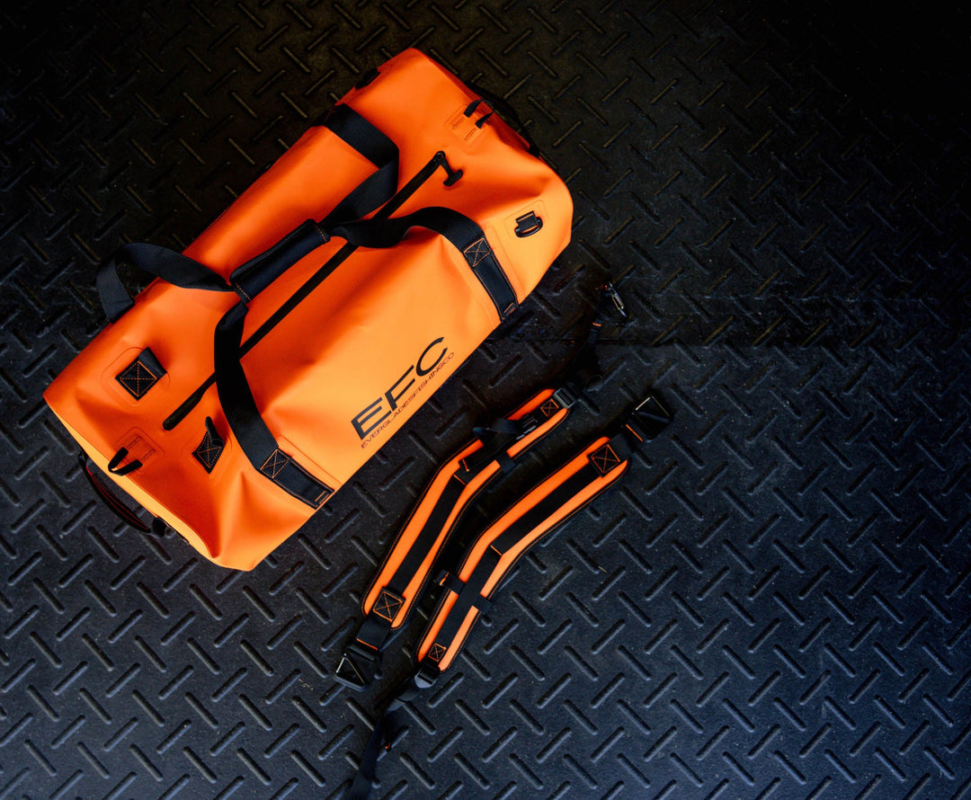 Everglades Fishing Co BALE BAG 50L dry duffel in bright orange, shown with sturdy handles and waterproof material.