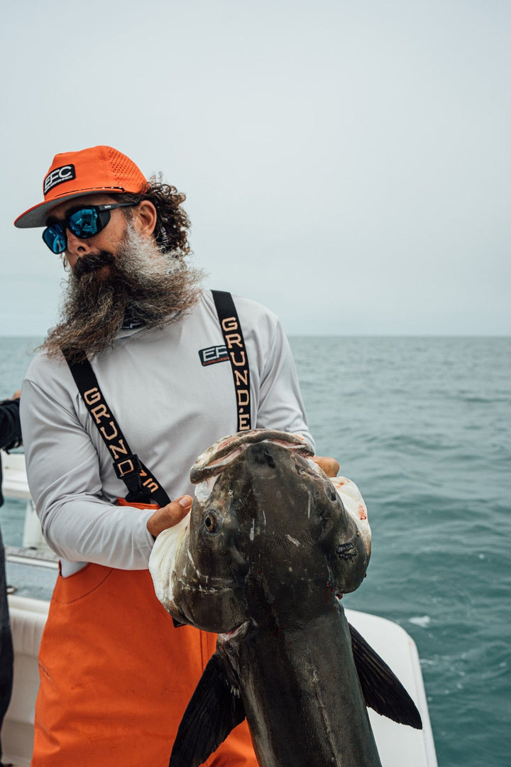 Man wearing a black Everglades Fishing Co Late Night Snapback cap with embroidered logo, facing sideways.
