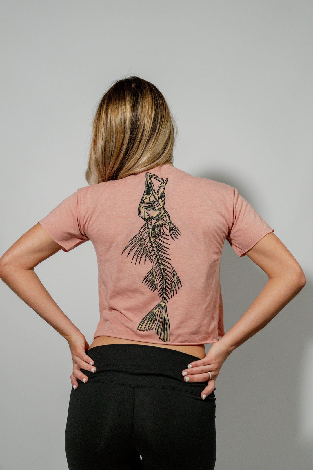 Everglades Fishing Co Snook Bones crop top in desert pink, showing the fitted short-sleeve style with Snook Bones graphic.