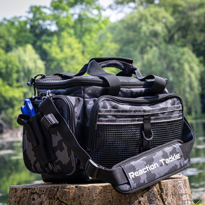 Reaction Tackle Camo Tackle Bag with multiple compartments, durable fabric, and adjustable straps for organized fishing gear storage.