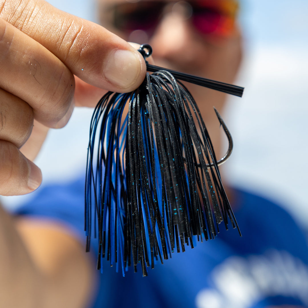 Reaction Tackle Tungsten Flipping Jigs 2-pack, showing two black and silver fishing jigs with weighted heads and sharp hooks.