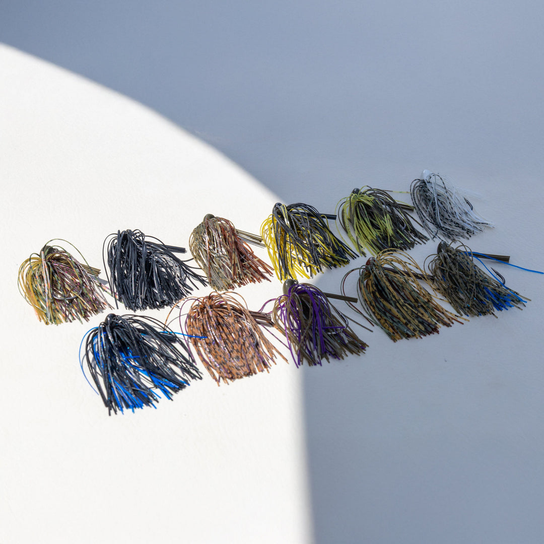 Reaction Tackle Tungsten Flipping Jigs 2-pack for fishing, featuring black and green jig heads with weed guards and sharp hooks.
