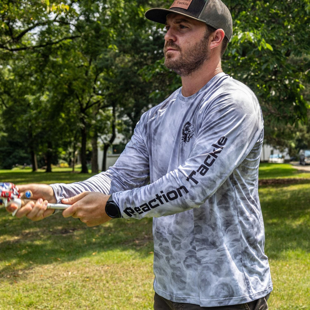 Gray Reaction Tackle SPF 50+ long sleeve fishing shirt with UPF protection, designed for sun-safe outdoor fishing activities.