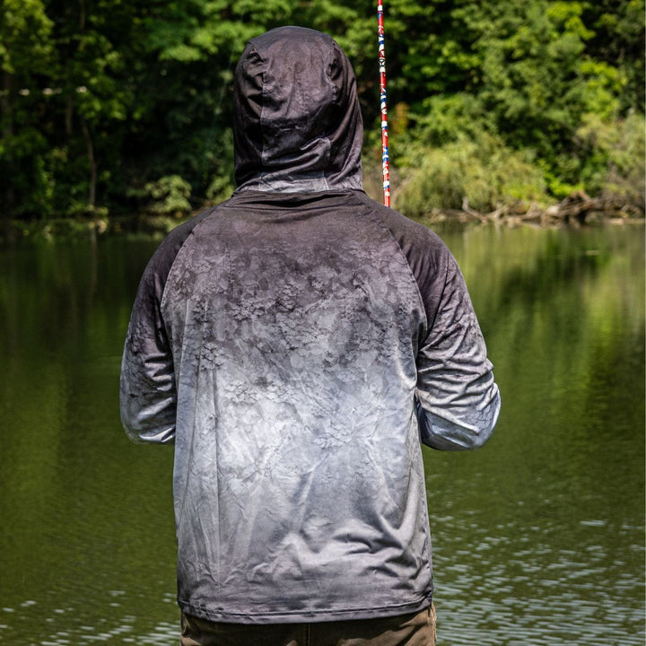 Black Reaction Tackle SPF 50+ long sleeve fishing shirt with hood and gaiter, designed for sun protection and outdoor fishing activities.