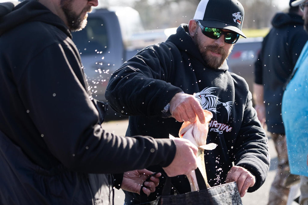 Black ShredFin Classic Hoodie with front pocket and drawstring hood, displayed on a hanger.