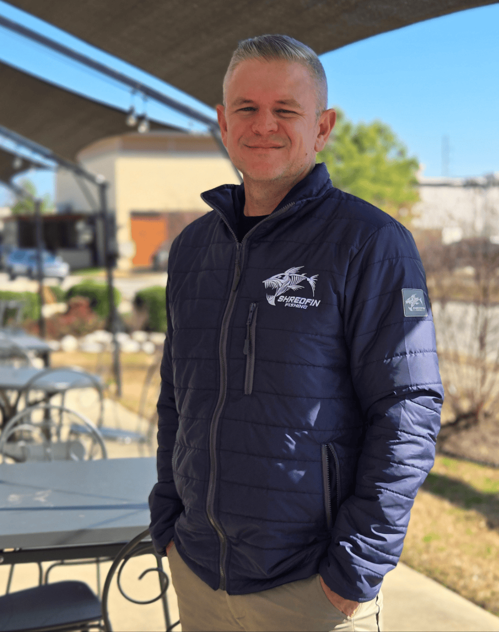 ShredFin Tailwindz Jacket in navy blue, lightweight waterproof outerwear with a hood and zippered pockets for outdoor activities.