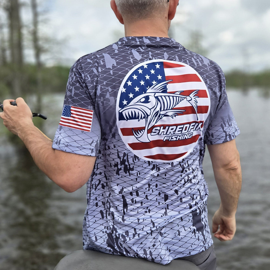 ShredFin Splash Camo Freedom short sleeve performance shirt with circle logo in tungsten gray fade, featuring camo pattern and athletic fit.
