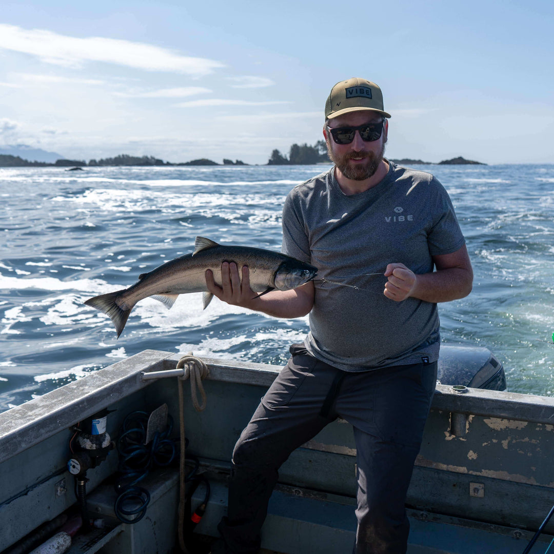 Vibe Performance T-Shirt by Vibe Kayaks, blue athletic apparel with logo, displayed on a hanger.